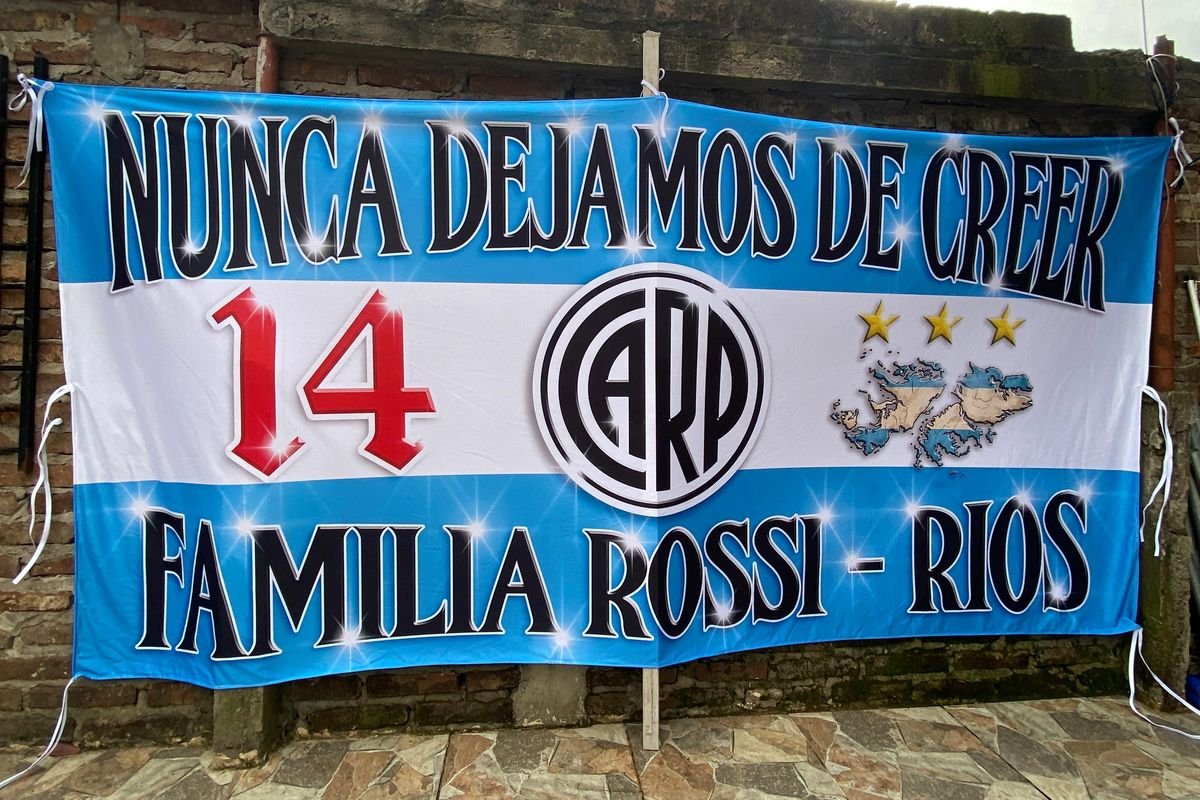 Bandera sublimada celeste y blanca de una familia hincha con la frase "Nunca dejamos de creer"